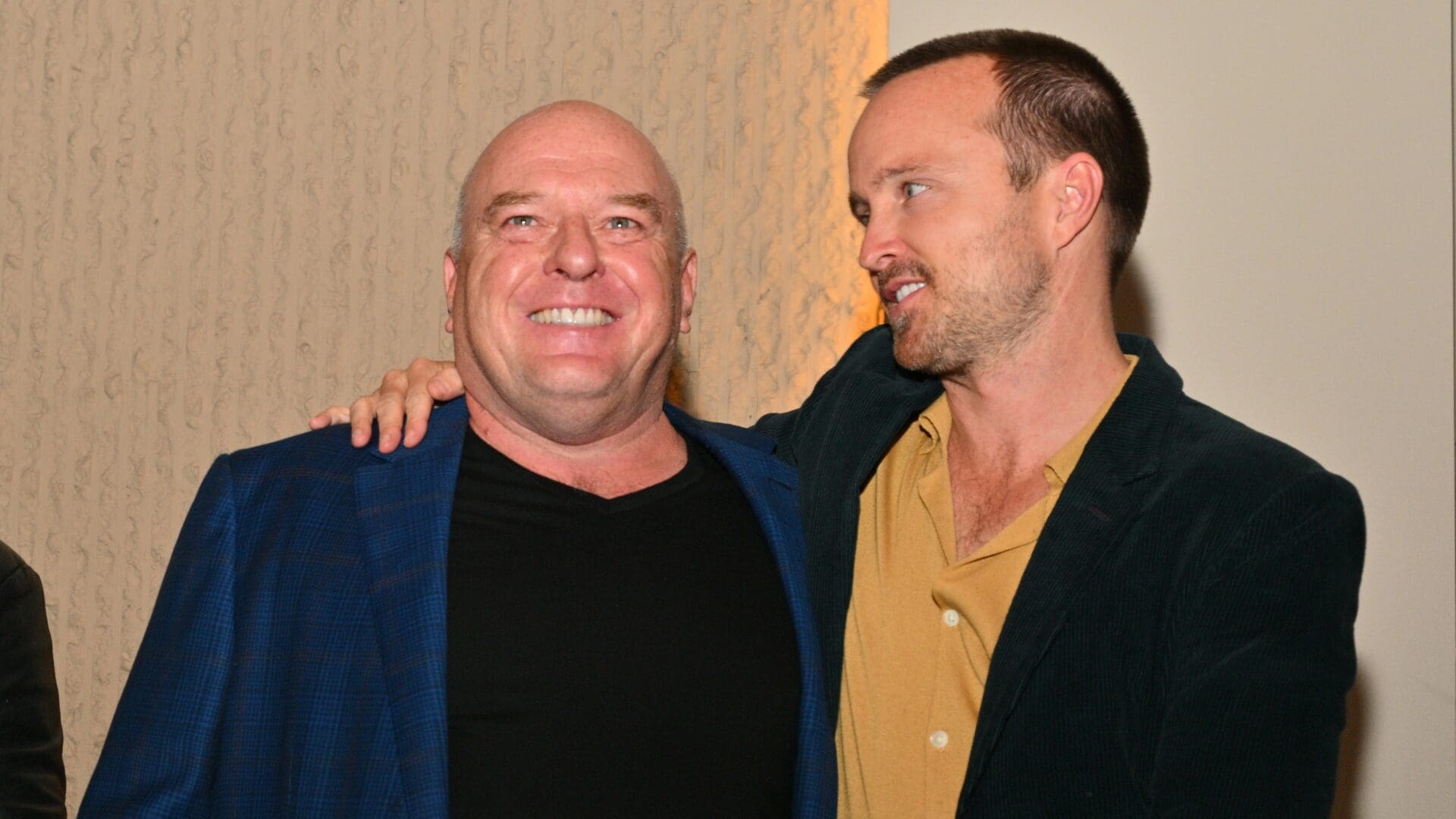 Actor Aaron Paul (R) hugs actor Dean Norris during an unveiling ceremony of bronze statues depicting television characters Walter White, played by actor Bryan Cranston, and Jesse Pinkman, played by Paul, from the series "Breaking Bad" at the Albuquerque Convention Center on July 29, 2022 in Albuquerque, New Mexico.
