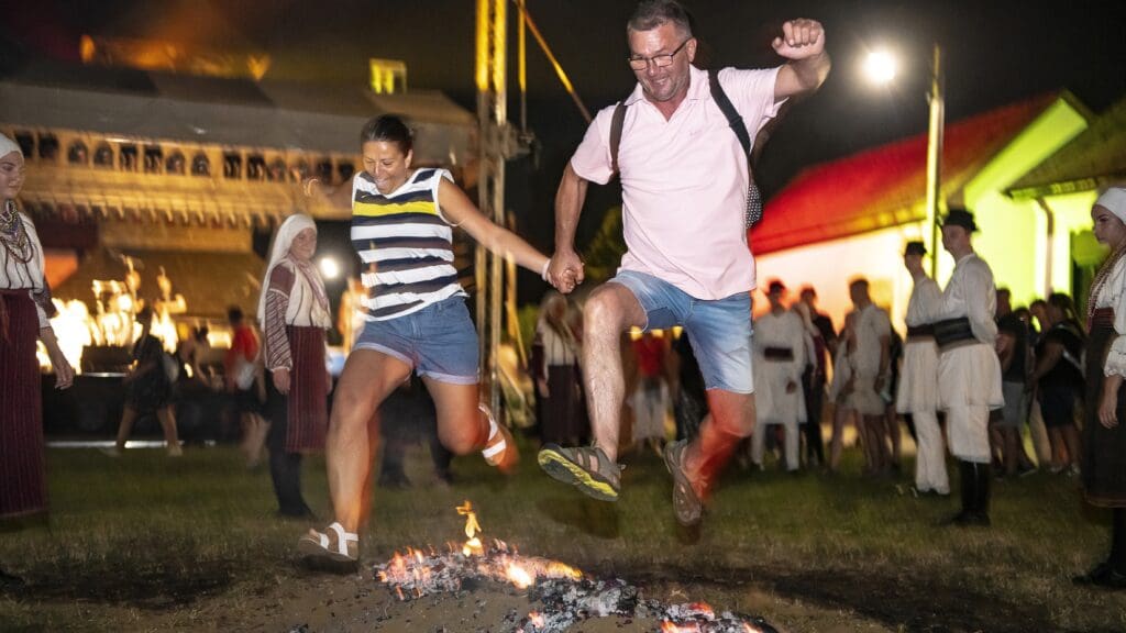 A couple jumping over fire on St Ivan's Night on 23 June 2021 in Nyíregyháza, at the Sóstó Village Museum.