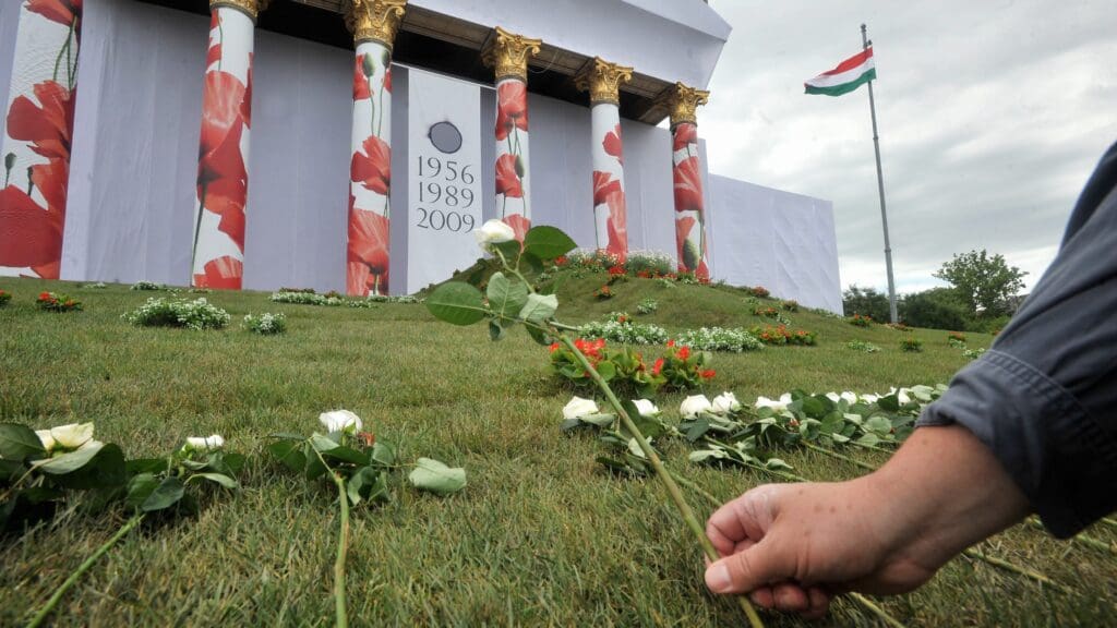 A man places a rose in front of Kunsthalle Budapest (Műcsarnok), commemorating the reburial of the late Prime Minister Imre Nagy and his fellow martyrs.