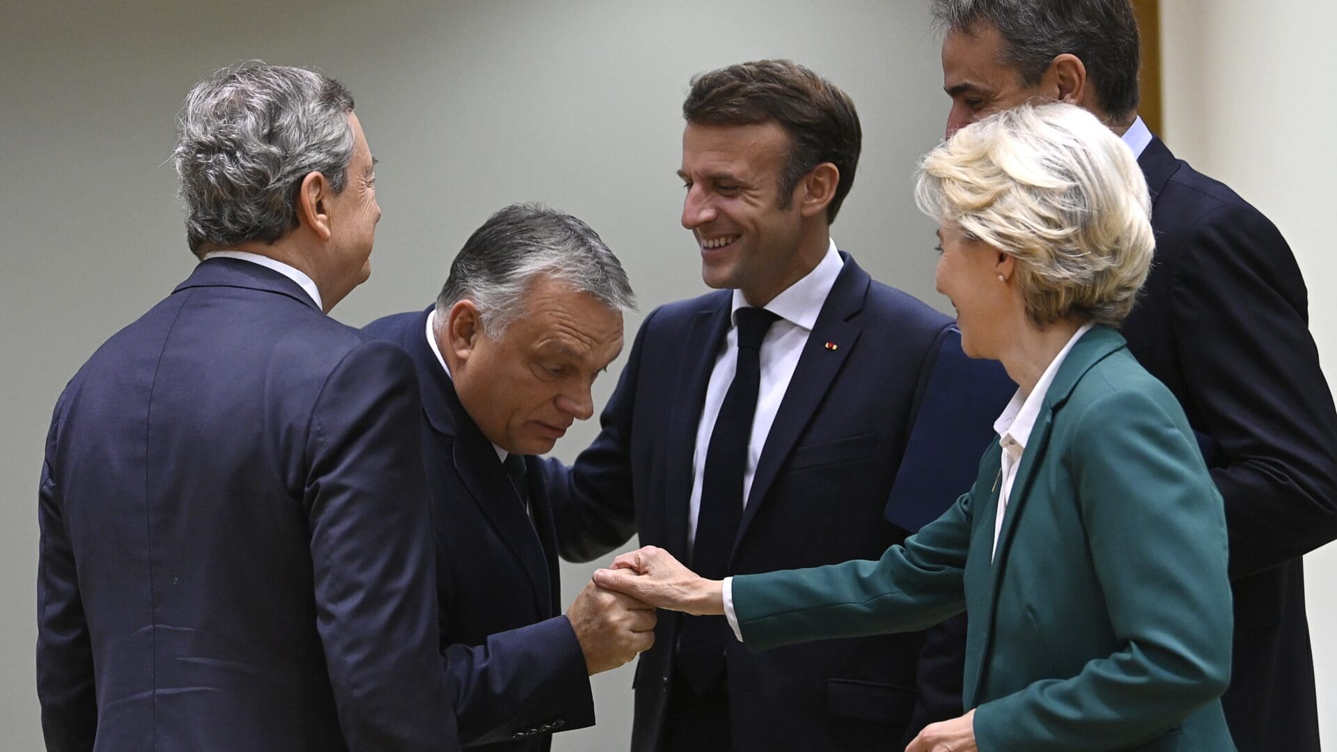 Hungary's Prime Minister Viktor Orban (2nd L) shakes hands with President of the European Commission Ursula von der Leyen (R) as Italy's Prime Minister Mario Draghi (L), France's President Emmanuel Macron (C) and Greece's Prime Minister Kyriakos Mitsotakis (2nd R) look on the second day of a EU leaders Summit at The European Council Building in Brussels on October 21, 2022.