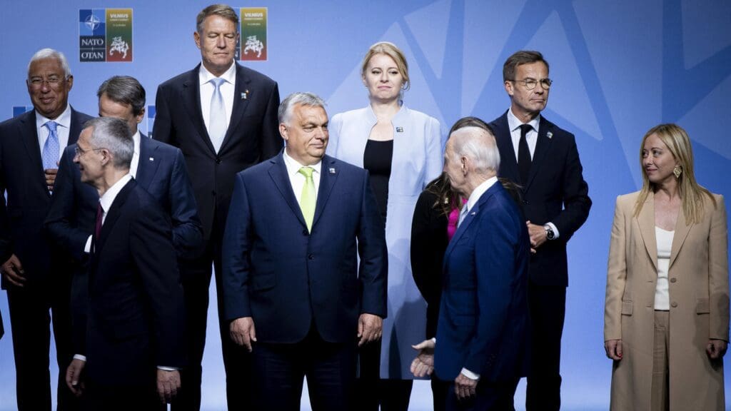 Viktor Orbán looks at Biden as the US President extends his hand to him before the group photo at the NATO Summit in Vilnius on 11 July 2023.