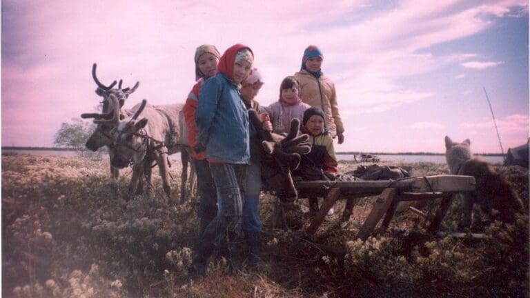 Khanty children in front of a reindeer sledge.