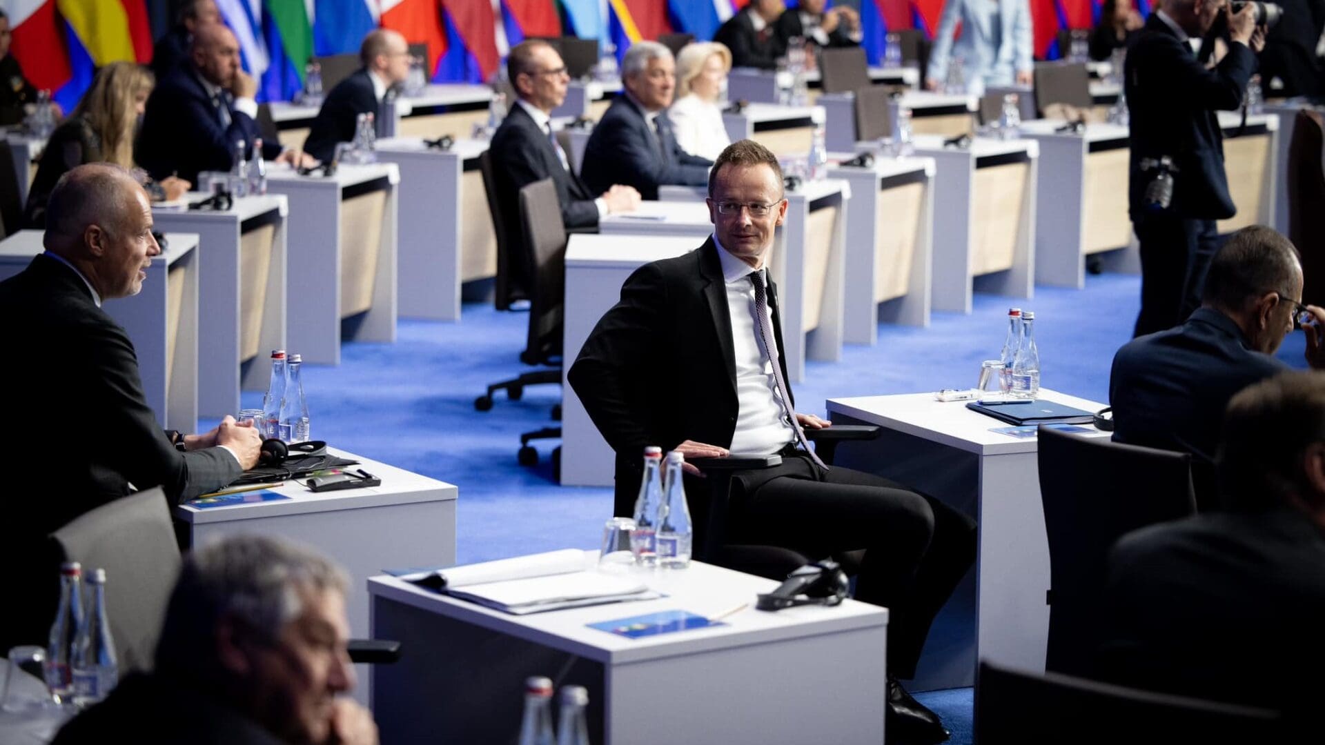 Péter Szijjártó turns back on his seat to exchange a glance with Defence Minister Kristóf Szalay-Bobrovniczky.