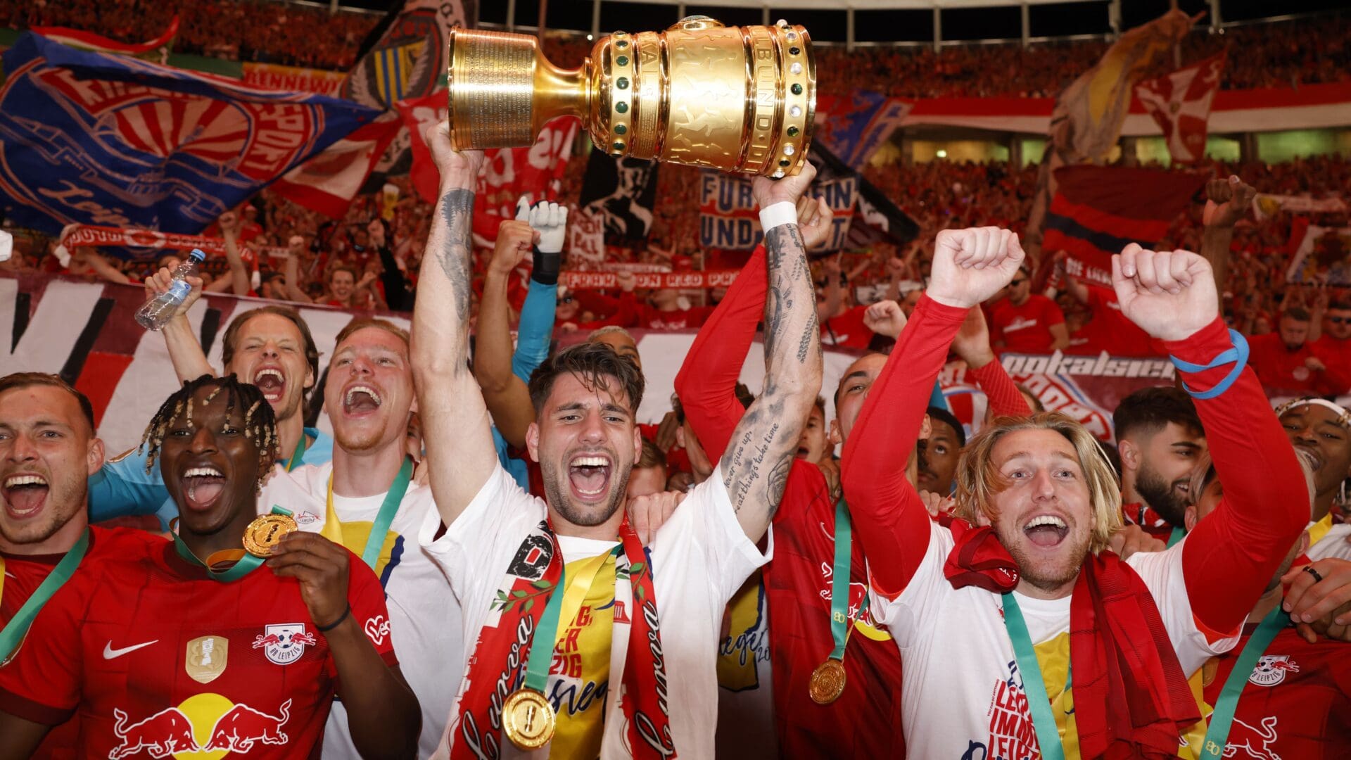 Leipzig's Hungarian midfielder Dominik Szoboszlai (C) and his teammates celebrate with the trophy after their team won the German Cup (DFB Pokal) final football match RB Leipzig v Eintracht Frankfurt in Berlin, Germany, on June 3, 2023.