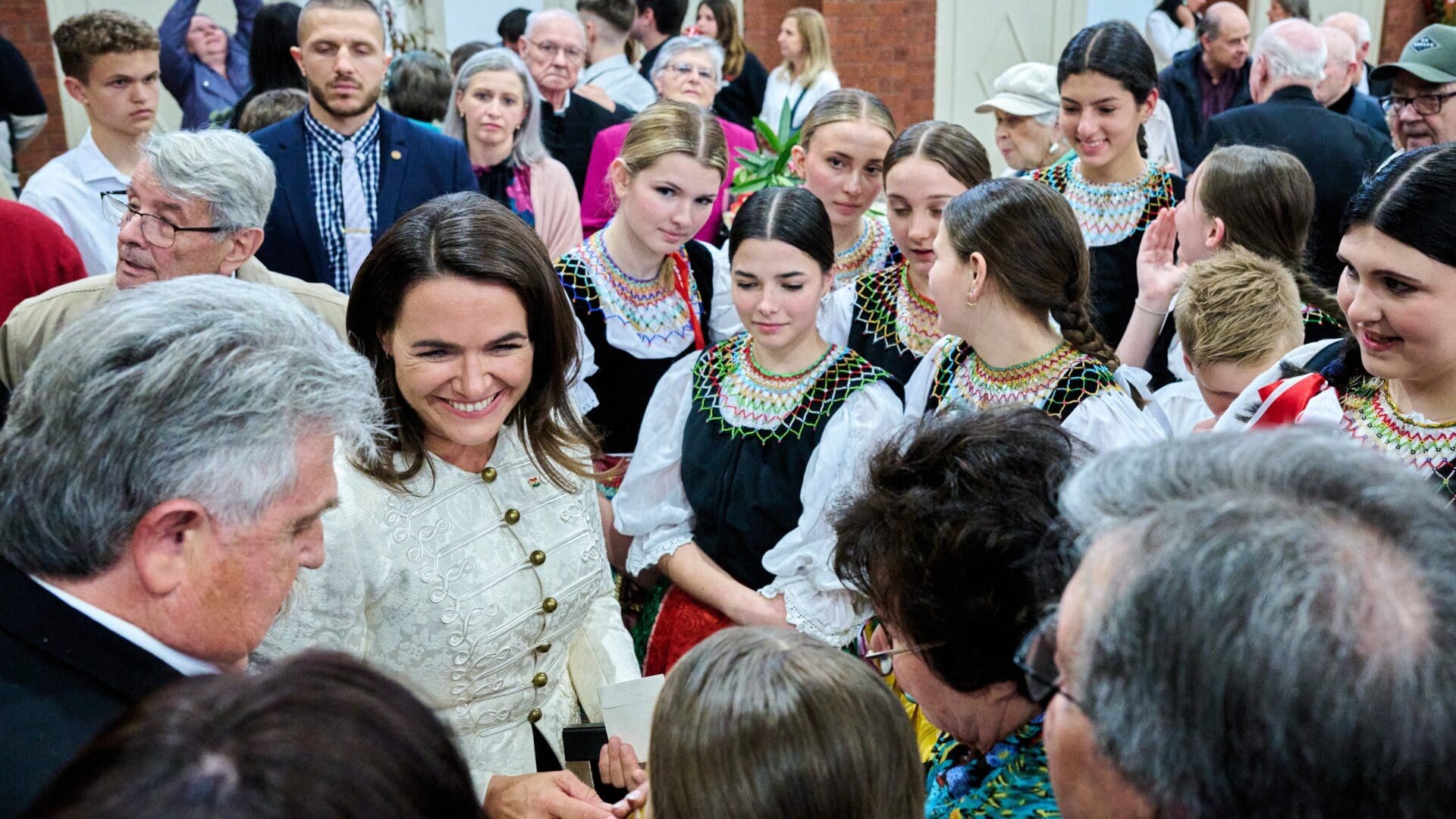 President Katalin Novák surrounded by Hungarian Australian youth wearing folk costumes at the Hungarian Centre in Melbourne, Australia on 22 October 2023.
