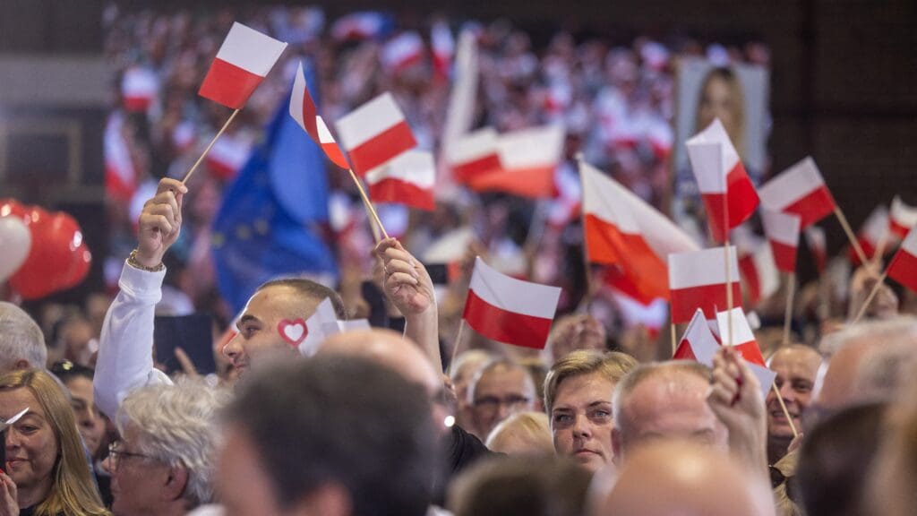 Supporters of the main opposition party Civic Coalition (PO) wave Polish flags at a rally in Pruszkow on 13 October 2023, the final day of campaigning before the parliamentary elections.