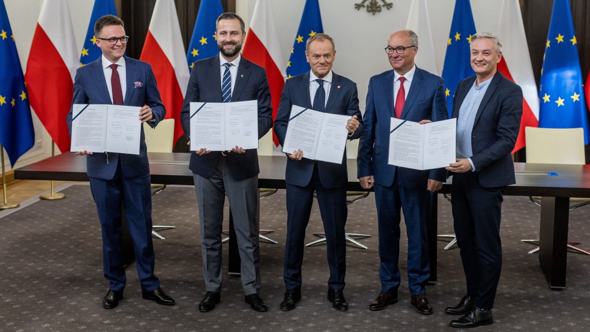 Leaders of the Polish liberal opposition parties (L-R) Szymon Holownia and Wladyslaw Kosiniak Kamysz of the Third Way party, Donald Tusk of the Civic Coalition, and Wlodzimierz Czarzasty and Robert Biedron of the Left party pose with the signed coalition deal at the Polish parliament in Warsaw on 10 November 2023.