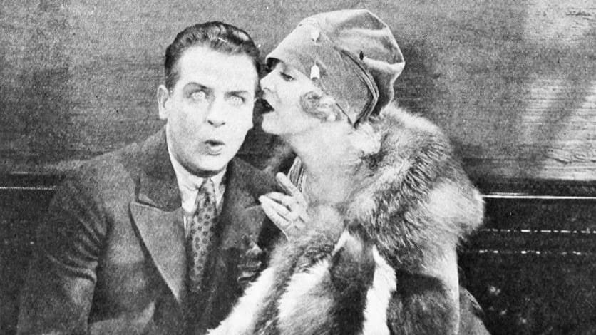 Still from the American comedy film The Cheerful Fraud (1927) with Reginald Denny and Gertrude Astor.