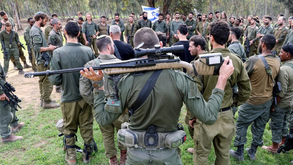 Israeli soldiers gather at the abandoned site of the Supernova music festival to commemorate the victims of the 7 October Hamas massacre near Kibbutz Reim in southern Israel on 17 December 2023.