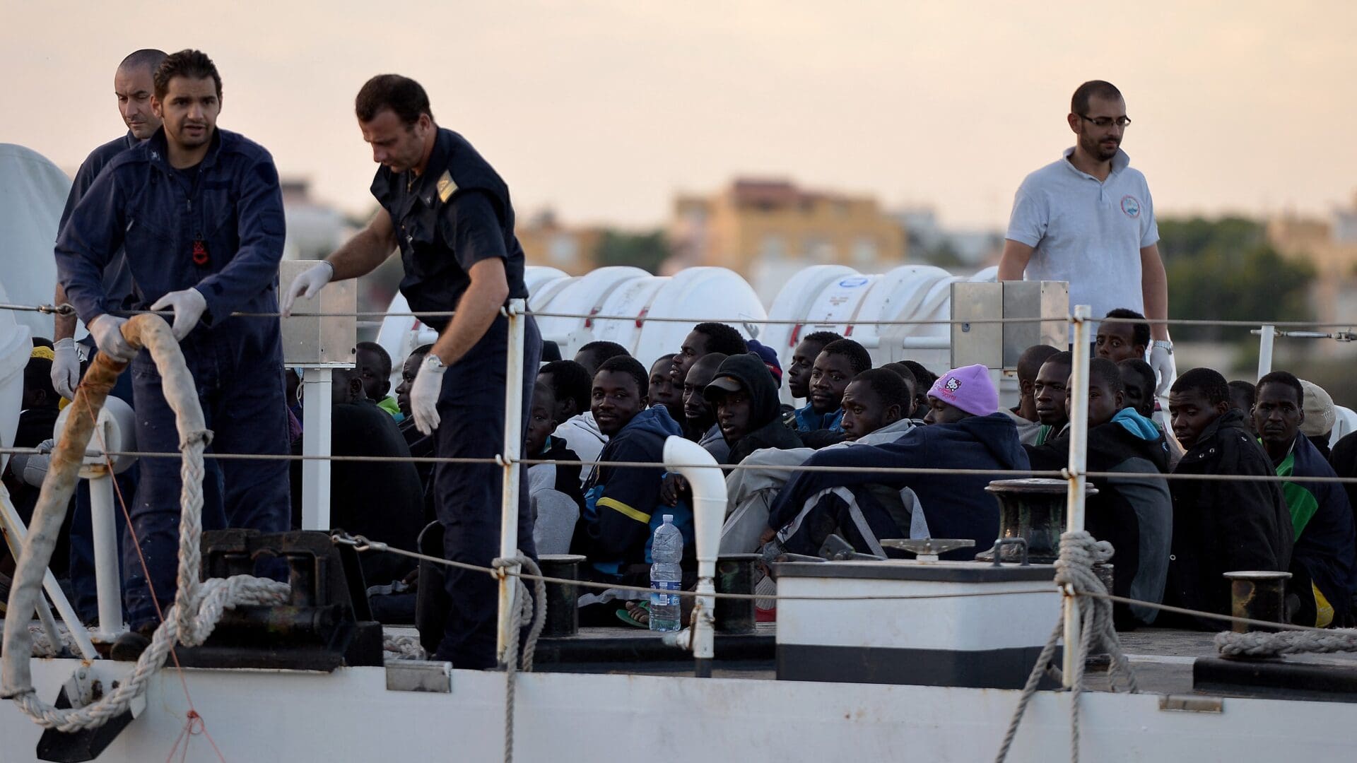 Some 100 migrants sit on the Guardia Costiera boat after being rescued off the shores of the island of Lampedusa on 25 October 2013 as part of the Italian Navy’s Mare Nostrum search-and-rescue operation launched after more than 400 migrants drowned in two disasters earlier that month.
