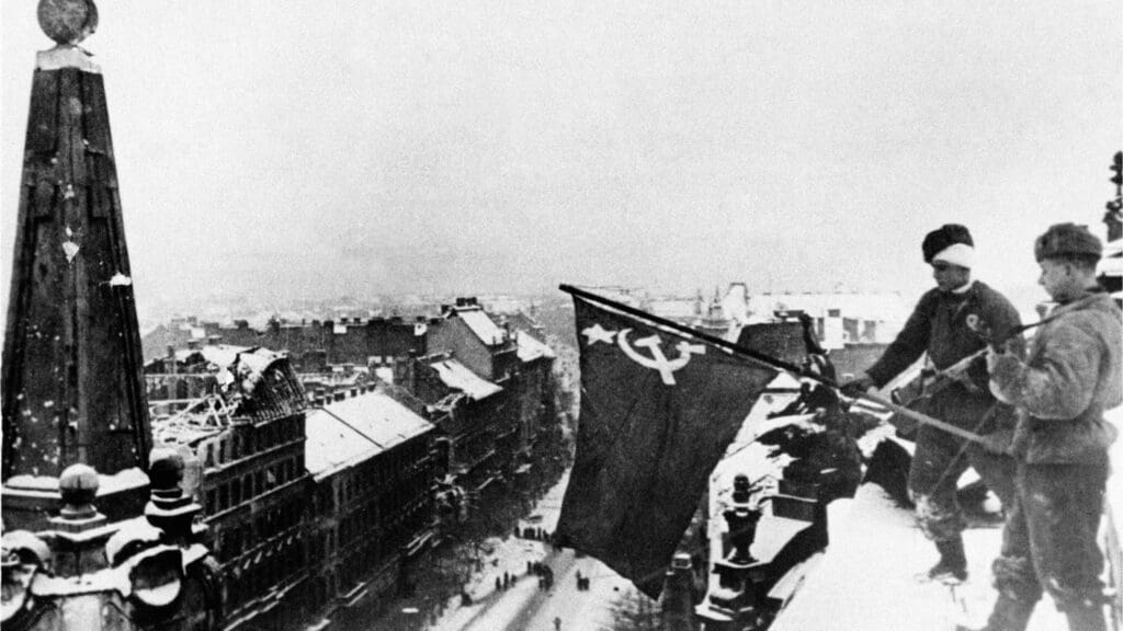 Soviet soldiers raise the red flag on top of the New York Palace in Budapest on 13 February 1945.
