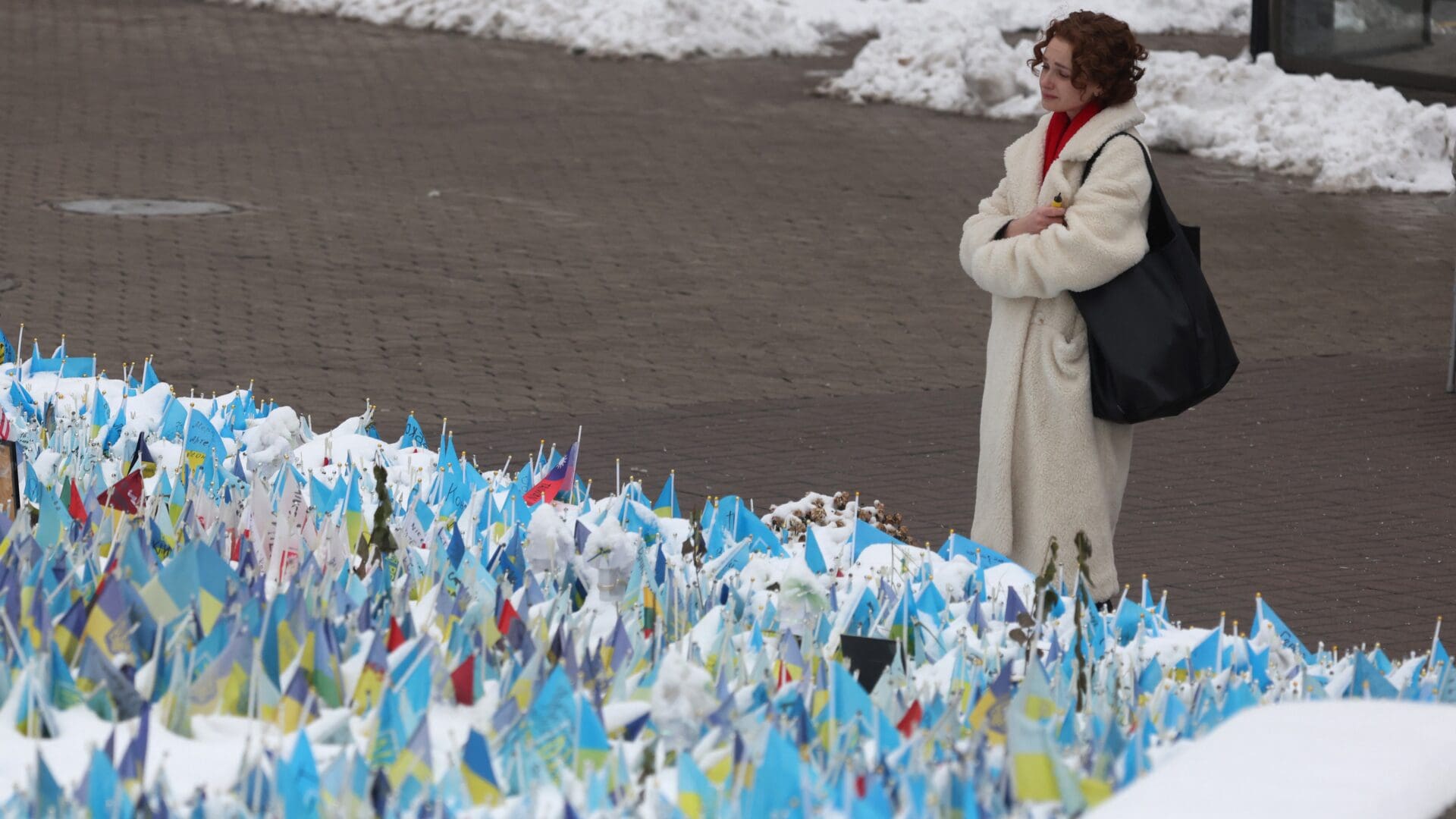 A woman looks at flags bearing symbols and colours of Ukraine that commemorate fallen Ukrainian soldiers in Independence Square, Kyiv on 1 December 2023.