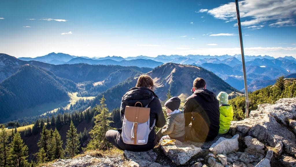 A family of four sitting at the top of a mountain (illustration, Pixabay)