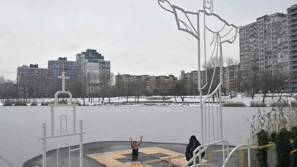A believer plunges into the waters of a lake during the Epiphany celebrations in Kyiv on 6 January 2024, amid the Russian invasion of Ukraine.
