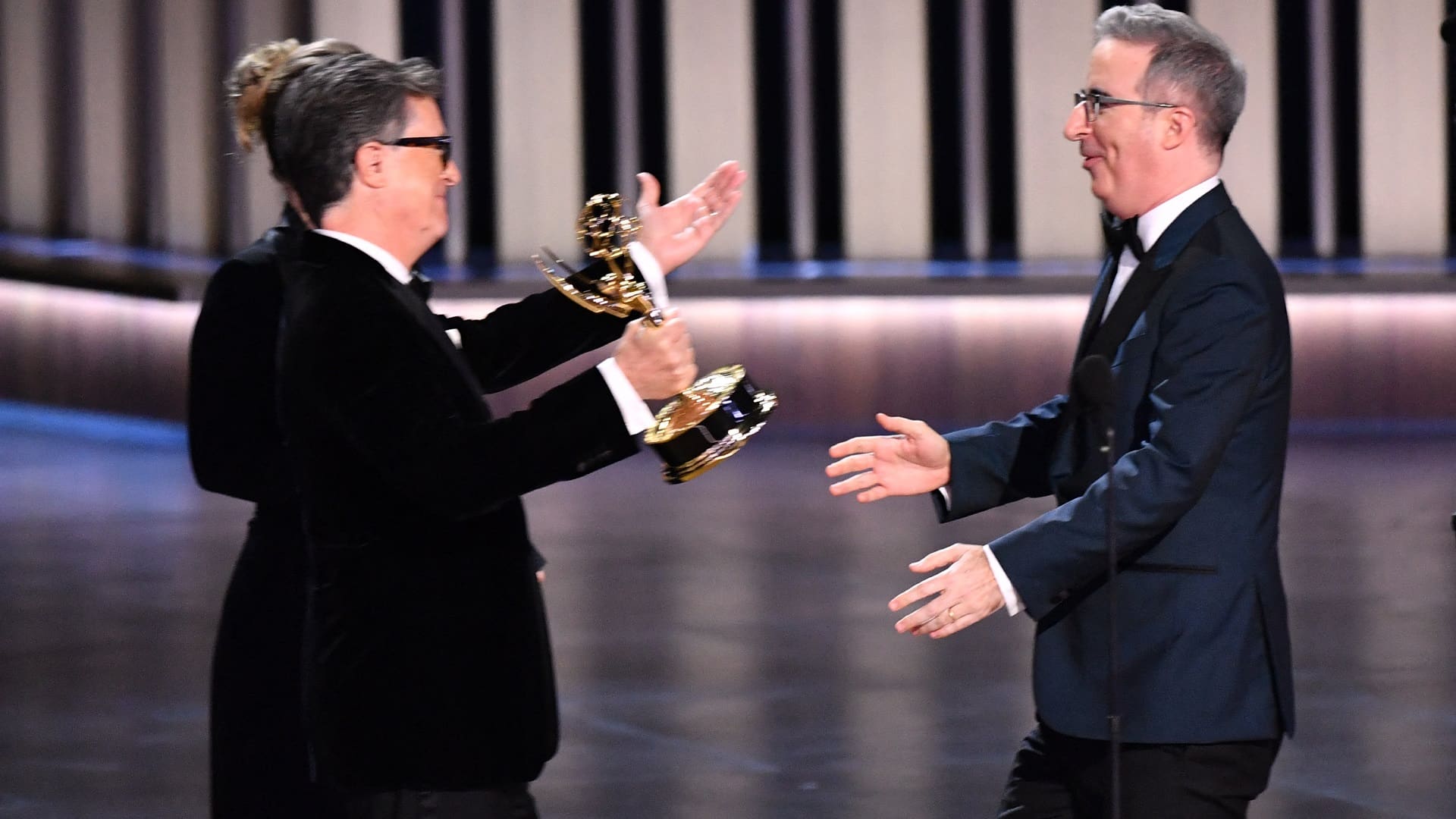 Stephen Colbert (L) presenting the Emmy Award to John Oliver (R).