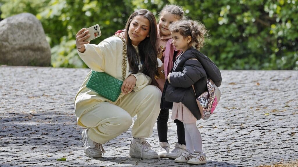 Mum takes selfie with small girl children (illustration)