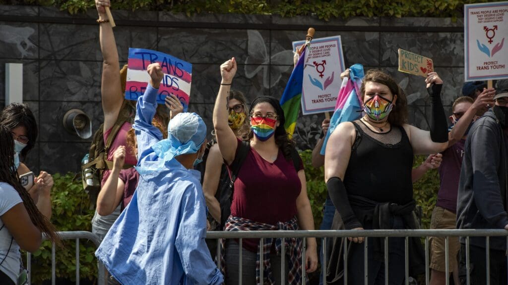 A medical worker cheers towards demonstrators calling for support of trans-children and gender affirmation treatments as they rally outside Boston Children’s Hospital in Boston, Massachusetts, on 18 September 18 2022.
