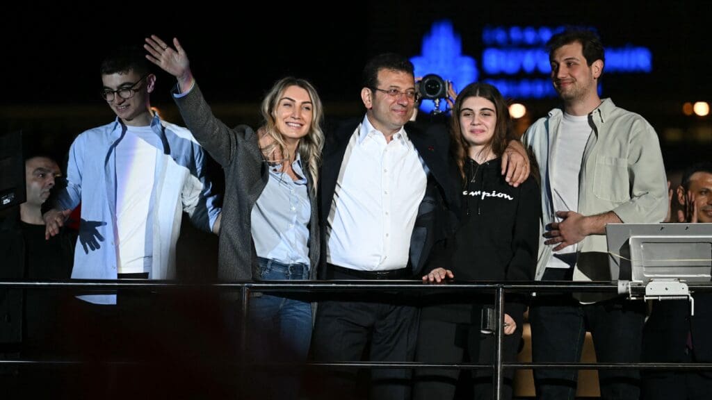 Istanbul's mayor and main opposition Republican People's Party (CHP) candidate Ekrem İmamoğlu with his wife Dilek Imamoğlu (2L) and family waves to supporters as they celebrate outside the main municipality building following municipal elections on 31 March 2024.