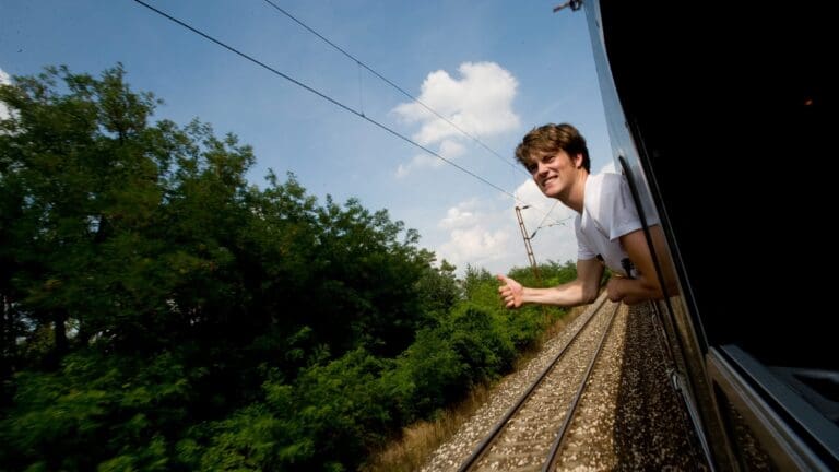 A young person leans out of the train window as it arrives from the Netherlands to the Sziget Festival in Budapest in 2011.