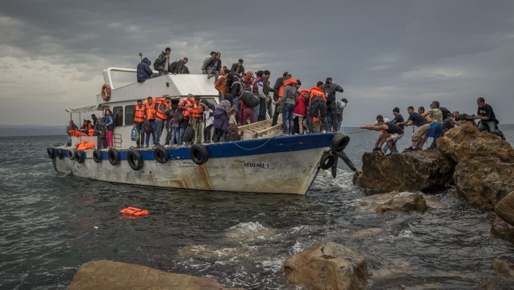 Refugees and Migrants aboard fishing boat drived by smugglers reach the Greek Island coast of Lesbos after crossing the Aegean sea from Turkey on 11 October 2015.