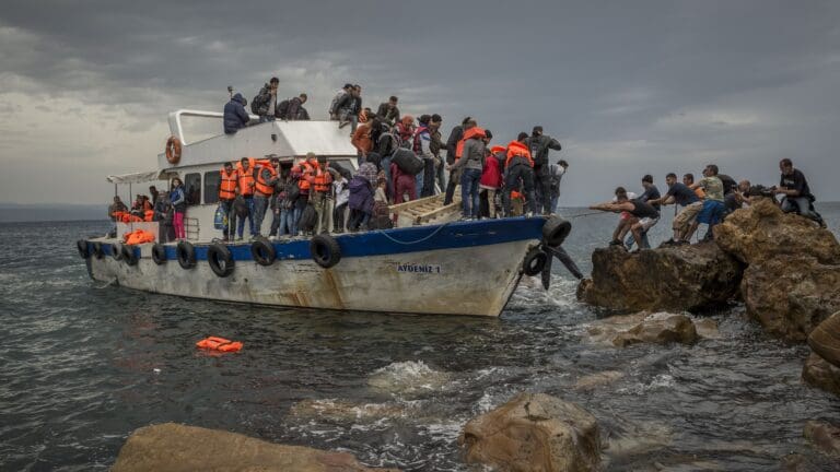 Refugees and Migrants aboard fishing boat drived by smugglers reach the Greek Island coast of Lesbos after crossing the Aegean sea from Turkey on 11 October 2015.
