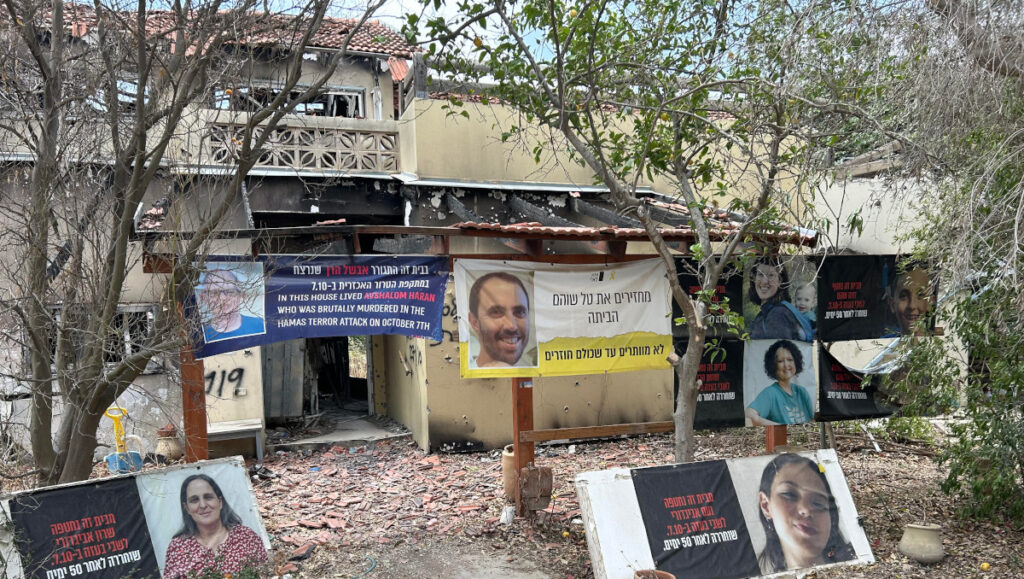 Portraits of victims in front of a house destroyed by terrorists in Kibbutz Be’eri PHOTO: Tamás Maráczi
