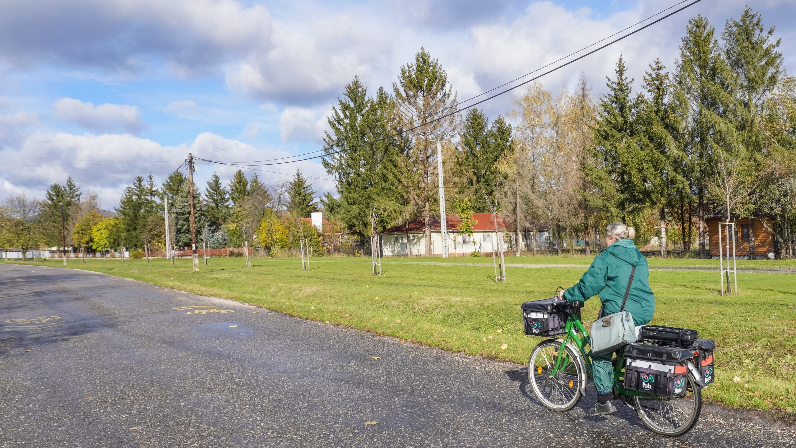 A woman postman is delivering letters on an electric bicycle with panniers adapted to transport parcels as she makes her way to mailboxes in Bogacs, Hungary, on November 8. (Photo by Michal Fludra/NurPhoto) (Photo by Michal Fludra / NurPhoto / NurPhoto via AFP)