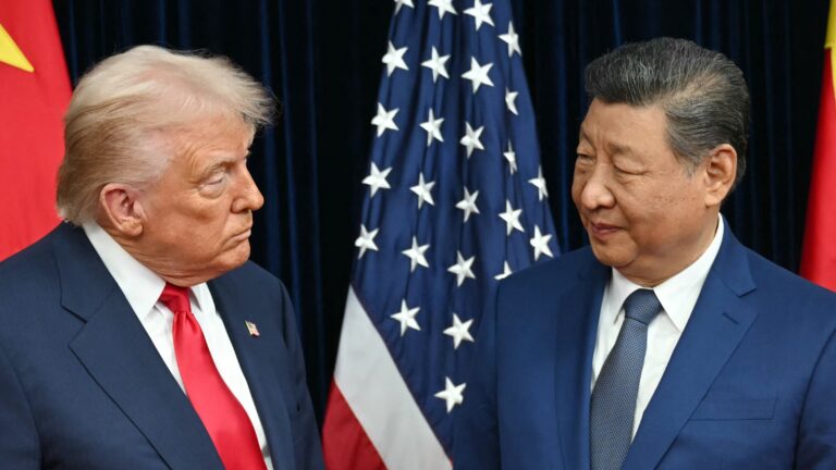 US President Donald Trump (L) and China's President Xi Jinping greet each other as they arrive for talks at the Gimhae Air Base, located next to the Gimhae International Airport in Busan on October 30, 2025.