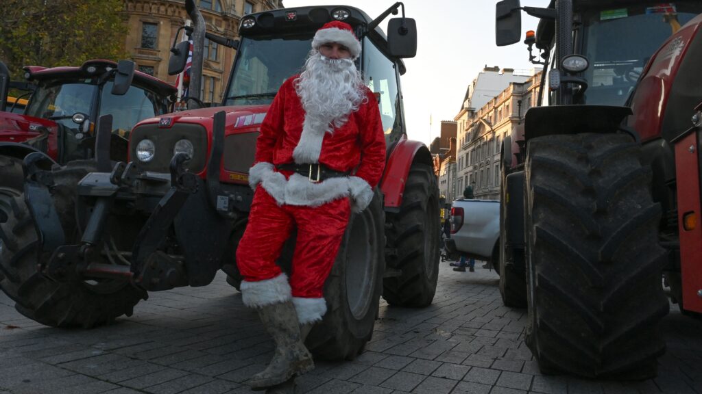 A farmer, wearing Santa costume, is seen as farmers from different regions of the United Kingdom gather with their tractors to protest on budget day, demanding fair reforms in agricultural policies and the reversal of changes to inheritance tax in London on November 26, 2025.