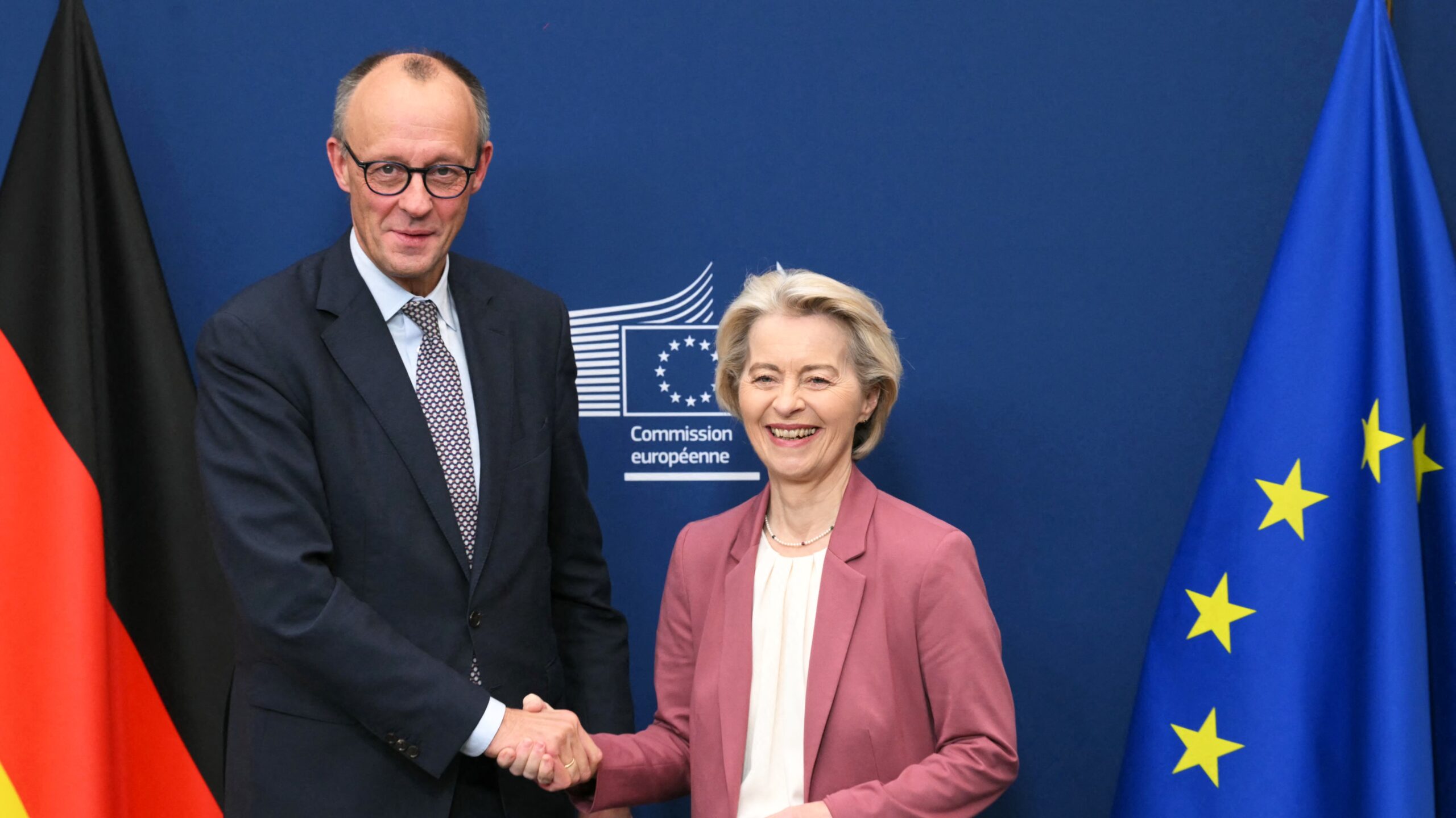 European Commission President Ursula von der Leyen greets Germany's Chancellor Friedrich Merz (L) to discuss the use of frozen Russian assets to finance Ukraine, at the EU Commission in Brussels on December 5, 2025.