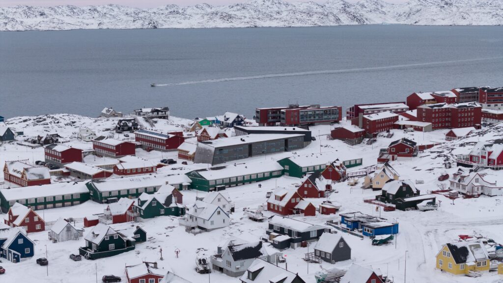An aerial view shows Nuuk, the capital of Greenland, with its colorful houses surrounded by snowy hills on January 13, 2026.