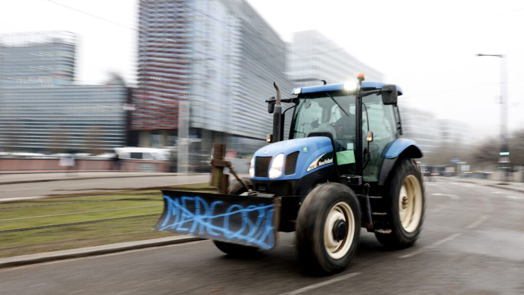 A tractor moves past the EU Parliament building in the background as farmers protest against the free trade agreement between the European Union and the Mercosur countries, on the day of a vote on a referral to the courts, in Strasbourg, eastern France on January 21, 2026.