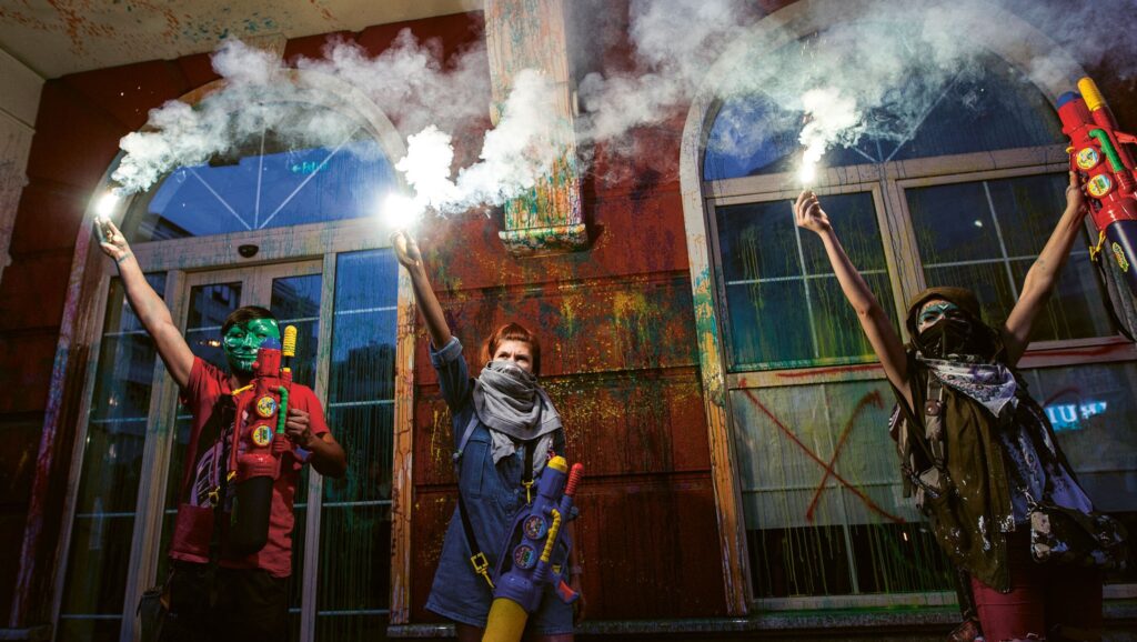 Protesters light flares after they sprayed paint on the facade of the Ministry of Justice building during an anti-government protest in Skopje, North Macedonia, 30 May 2016