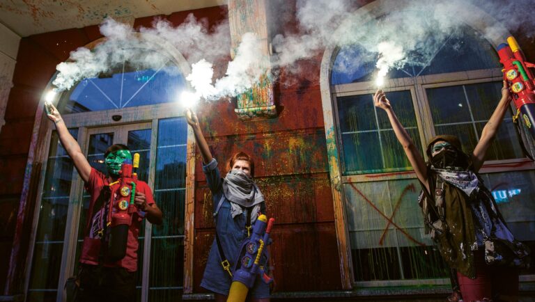 Protesters light flares after they sprayed paint on the facade of the Ministry of Justice building during an anti-government protest in Skopje, North Macedonia, 30 May 2016